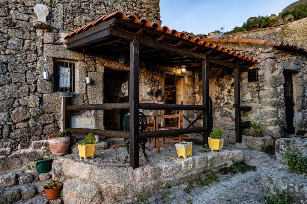 ein Steinhaus mit einer Terrasse davor in der Unterkunft SUN SET HOUSE in Monsanto