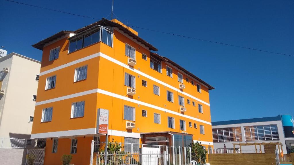 ein orangefarbenes Gebäude mit weißen Zierleisten in der Unterkunft Pousada Milani in Florianópolis