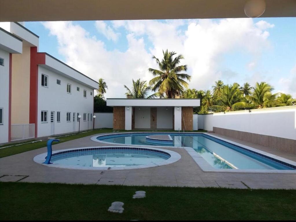 a swimming pool in a yard next to a building at Praia do Frances in Praia do Frances