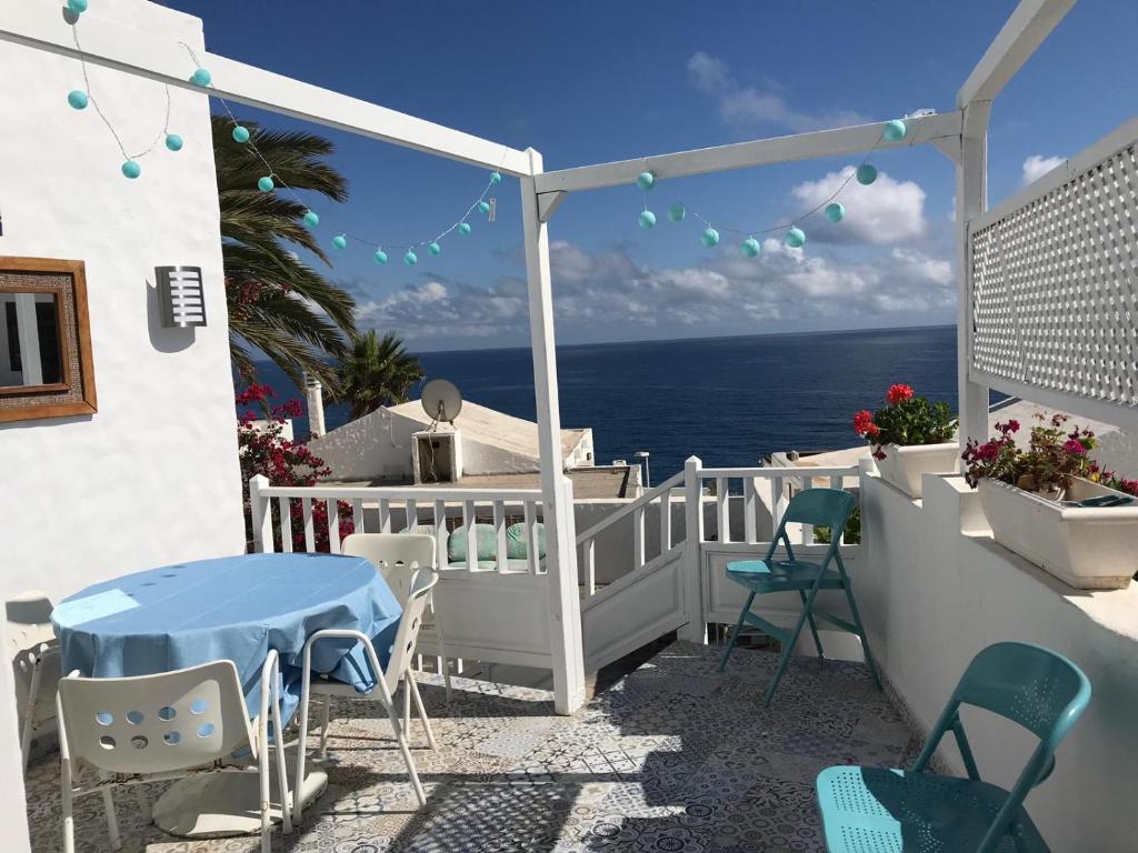 uma varanda com uma mesa e cadeiras e o oceano em San Agustín Seaviews and flowers em San Agustin