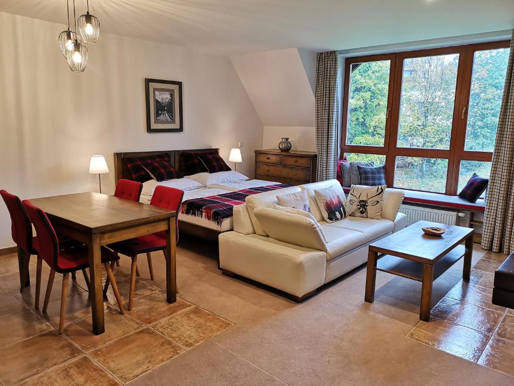 a living room with a bed and a table at Family apartment in Tatranska Lomnica in Tatranská Lomnica