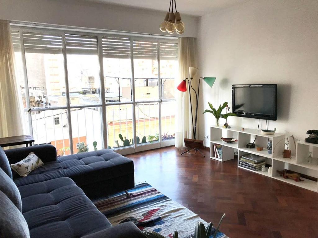 uma sala de estar com um sofá e uma televisão de ecrã plano em Depto centrico, 90 m2, 2 habitaciones em Rosário