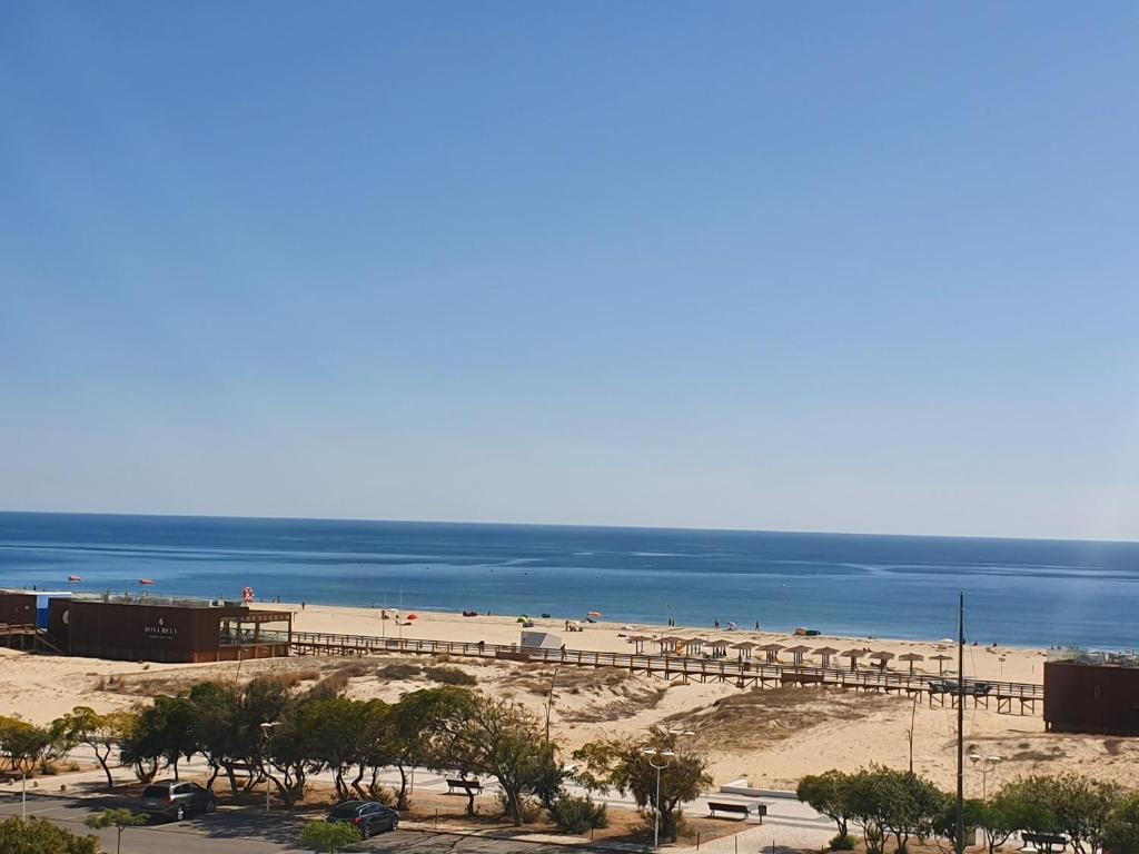 a view of a beach with a pier and the ocean at Apartamento Atlantico - Vista Mar in Monte Gordo