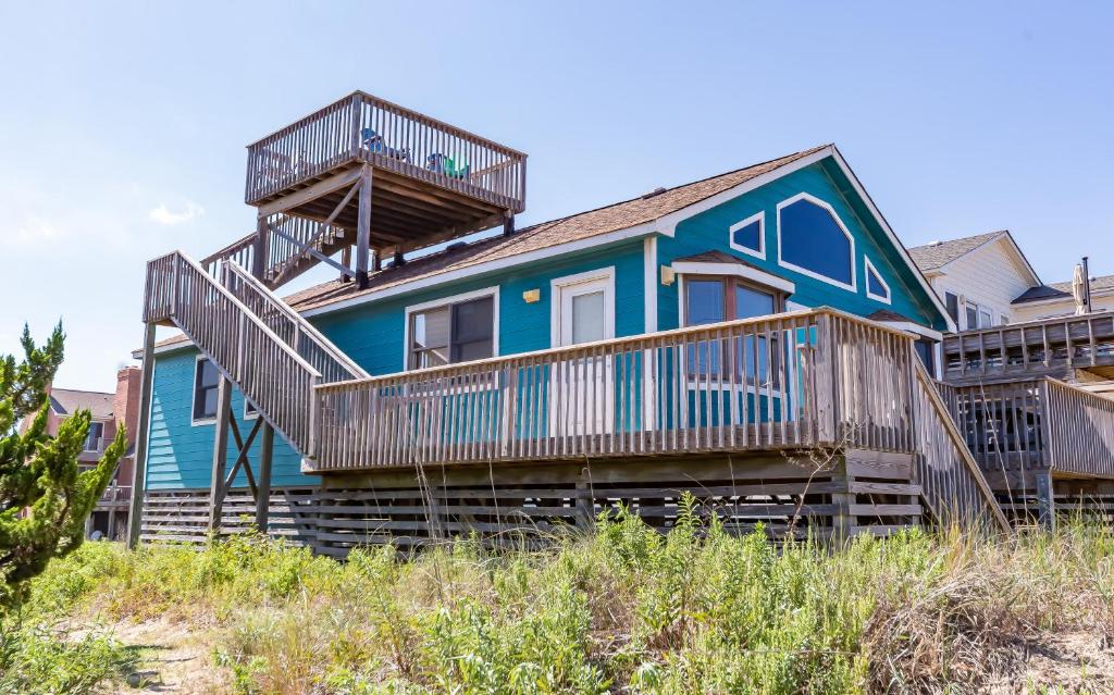une maison bleue avec des terrasses sur la plage dans l'établissement Escape to Paradise, à Kitty Hawk