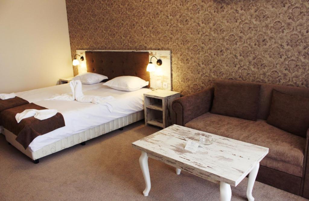 a hotel room with a bed and a couch at Paraiso Theopolis - All Inclusive in Obzor