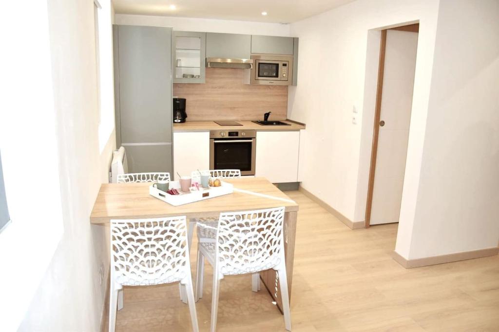 a kitchen with a table and chairs in a room at Bel appartement situé quartier Louvre-Bollaert in Lens