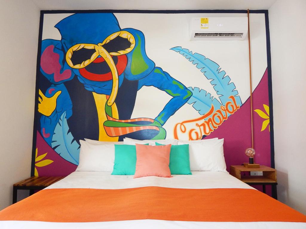 Schlafzimmer mit einem Bett mit Wandbild in der Unterkunft ETHNIC Thematic Hotel in Cartagena de Indias