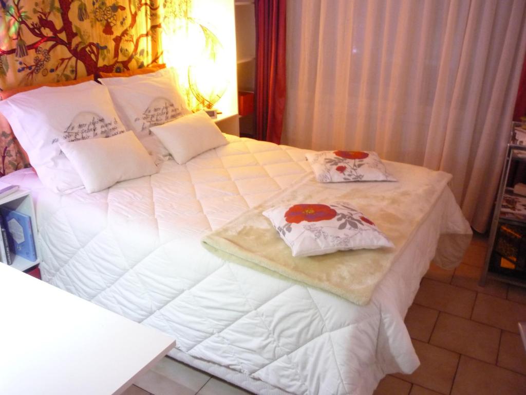 un grande letto bianco con due cuscini sopra di MINI TARIF pour un MAXI CONFORT a Berck-sur-Mer