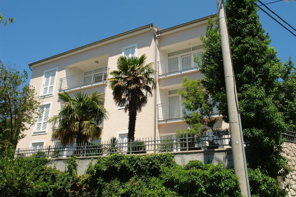 un edificio blanco con palmeras delante en Apartment Villa Sara en Dramalj
