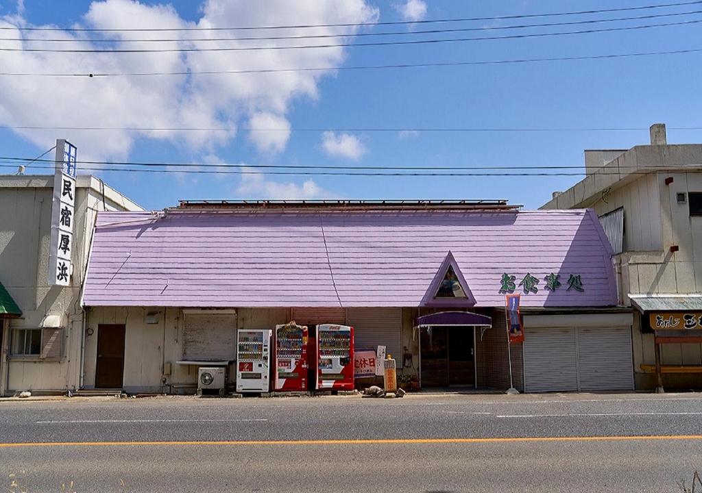 a building with a purple roof on the side of a street at Minshuku Atsuhama in Sumoto