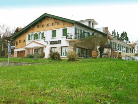 une grande maison installée au-dessus d'un champ verdoyant et luxuriant dans l'établissement Gurutzeberri, à Oiartzun