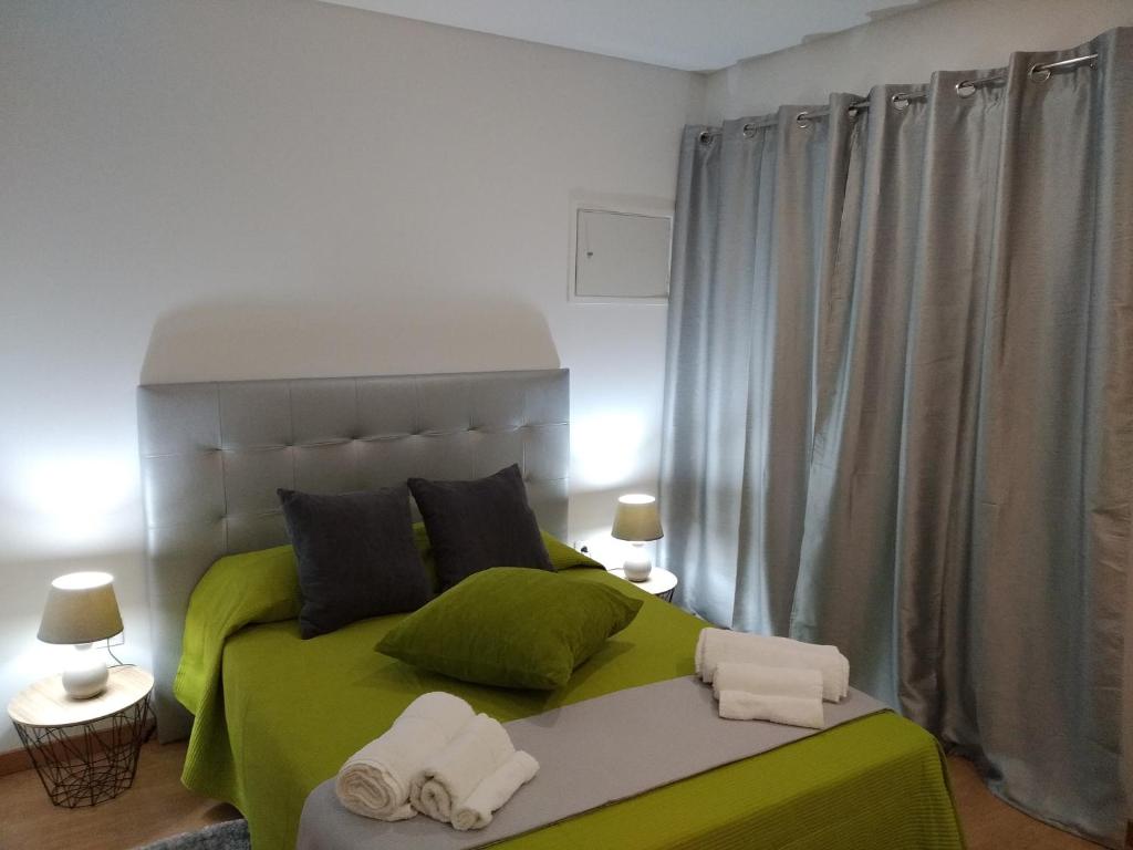 sypialnia z zielonym łóżkiem i ręcznikami w obiekcie Casa Do Boteco w mieście Santa Marta de Penaguião