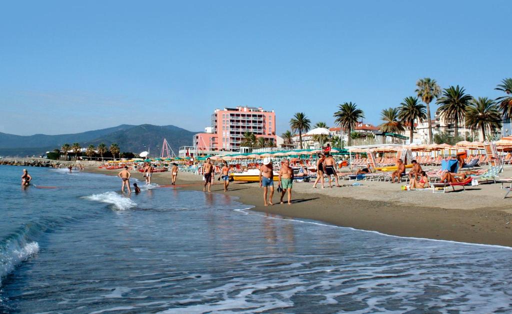 a group of people on a beach with buildings at Appartamenti Lungomare Savona in Savona