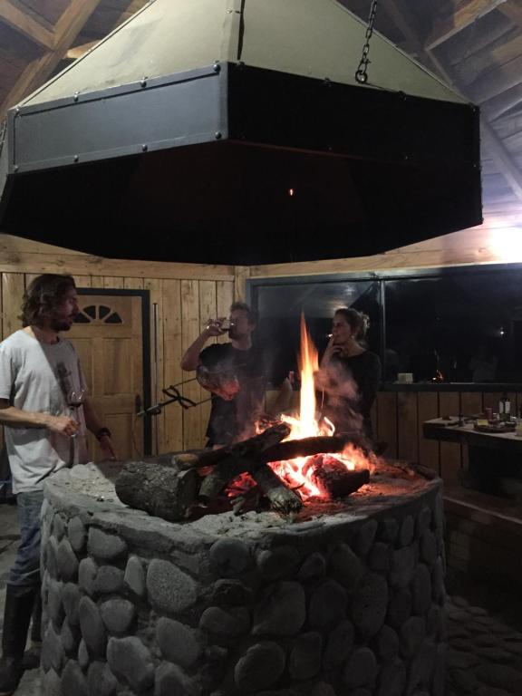 Un gruppo di persone intorno a un focolare di Cabañas Parque Michimahuida a Chaitén