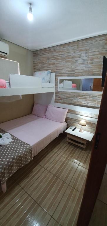 a small bedroom with a bunk bed and a table at Pertinho do Aeroporto Hospedagem Particular in Várzea Grande