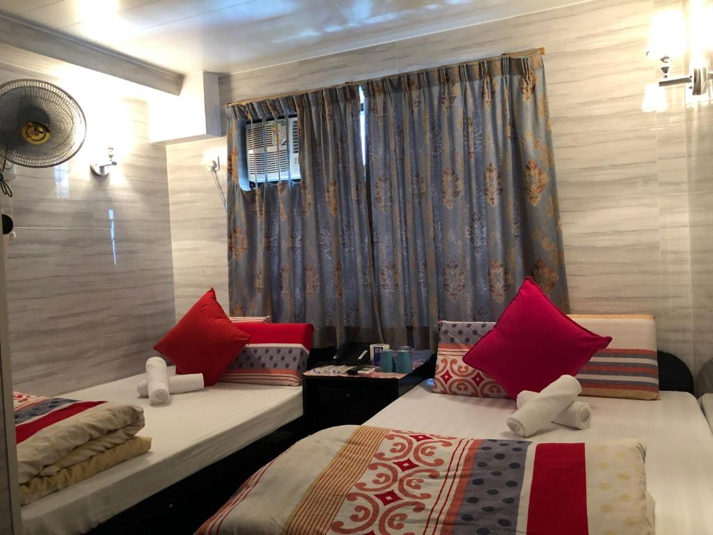 um quarto com 2 camas e uma janela em Dreamland Guest House em Hong Kong
