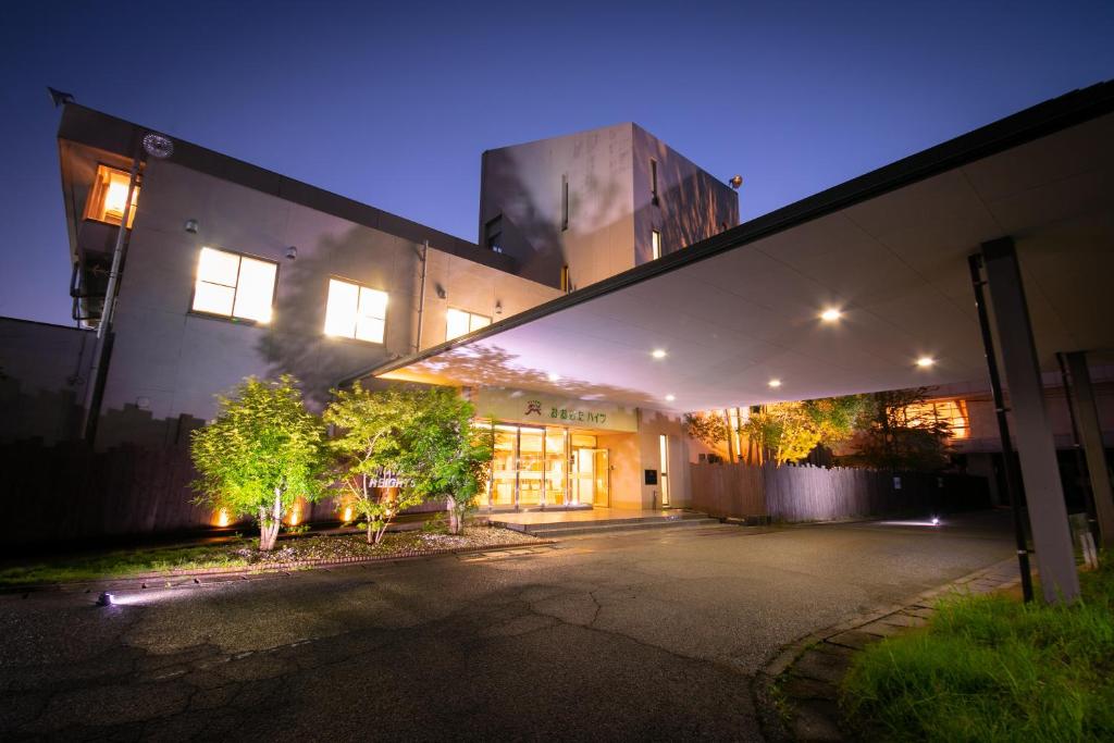 a large building with a lit up facade at night at Omuta Heights in Ōmuta