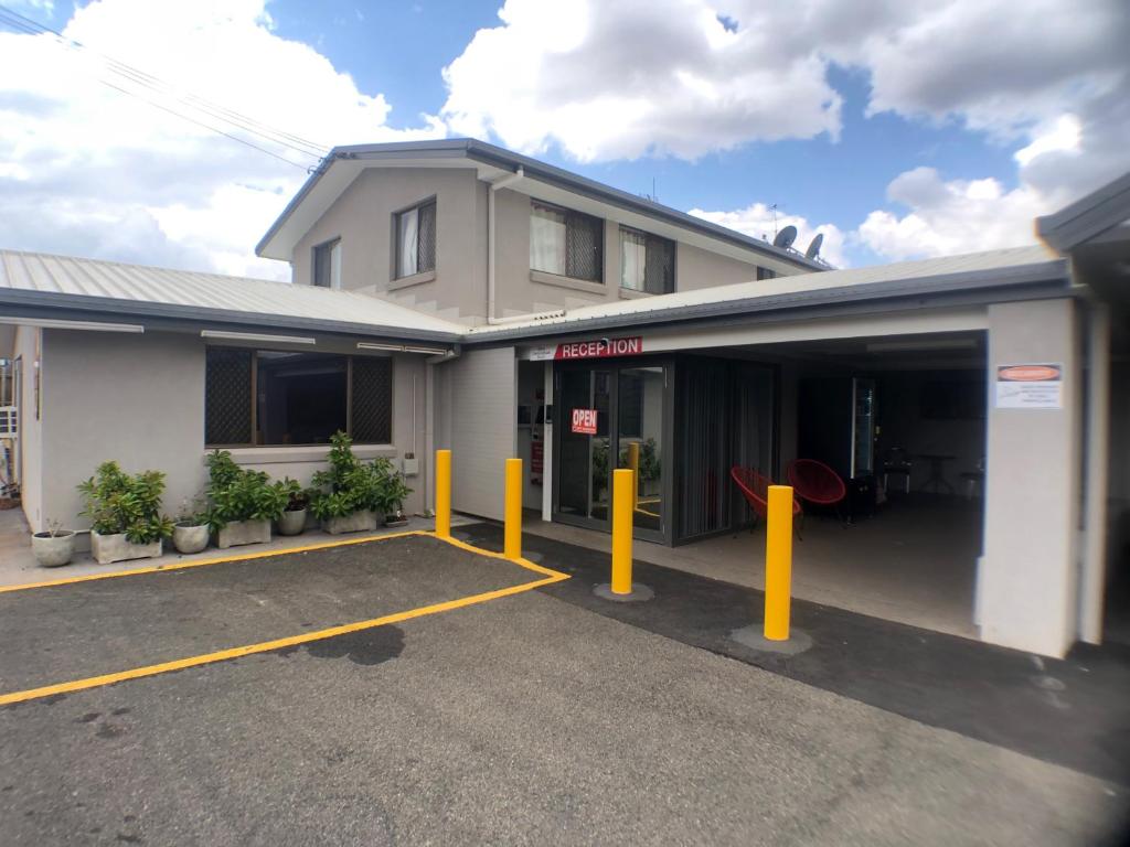 a building with yellow poles in a parking lot at Allan Cunningham Motel in Toowoomba