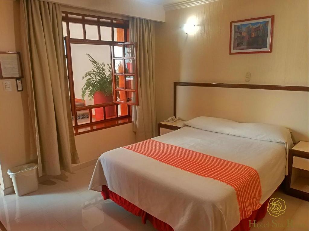 a hotel room with a bed and a window at Hotel Santa Rosa in Oaxaca City