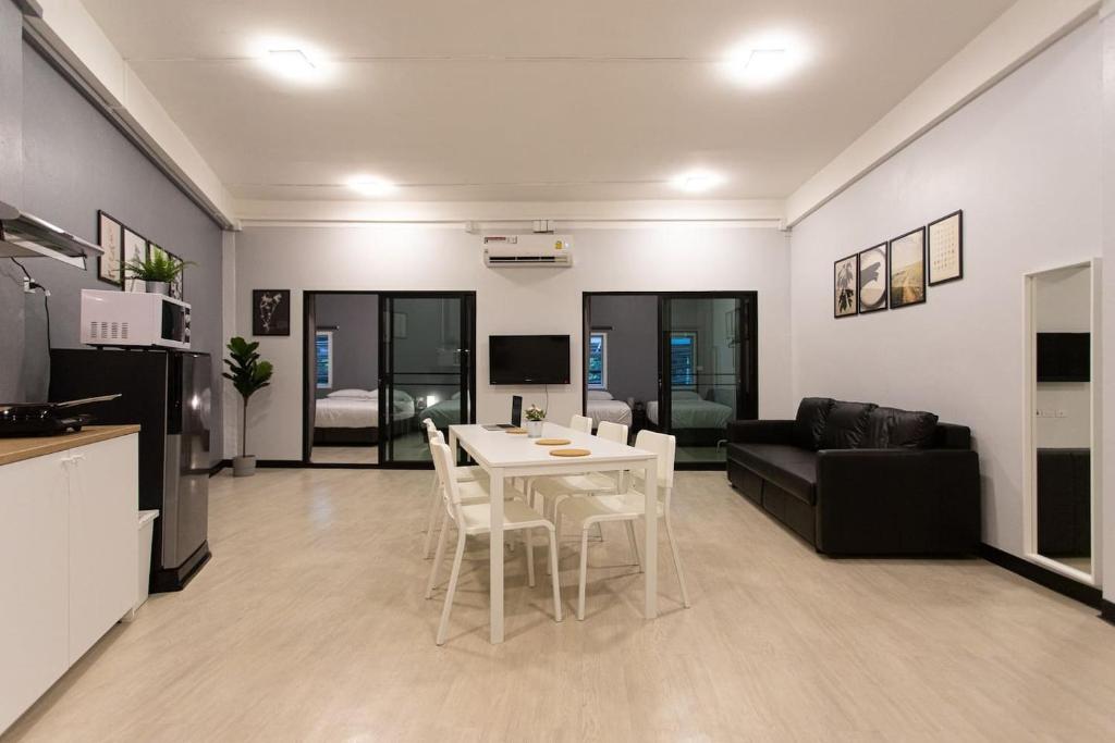U2 Large 2 Bedrooms 100m to BTS station في بانكوك: مطبخ وغرفة معيشة مع طاولة وكراسي