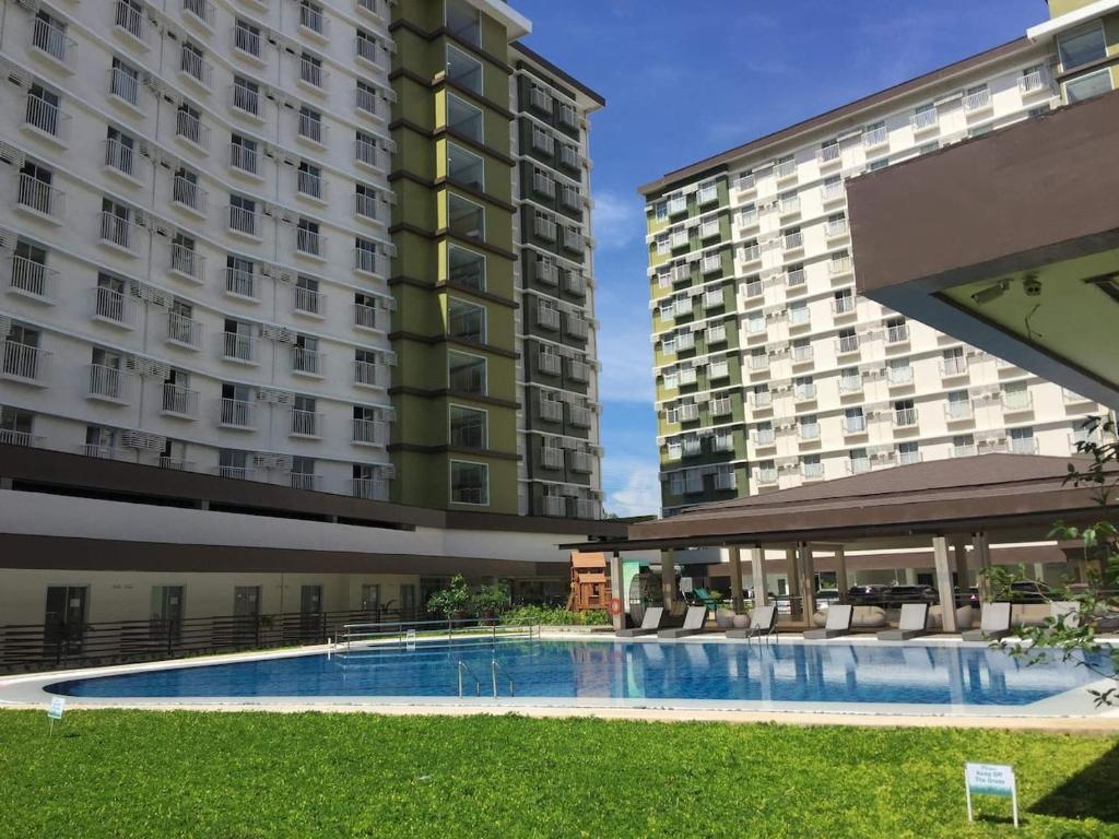 a swimming pool in front of two buildings at Bamboo Bay Condominium near UC Med & Chong Hua Hospital, CDU School, SM Mall, Ayala Mall and IT Park - studio condo unit in Cebu City