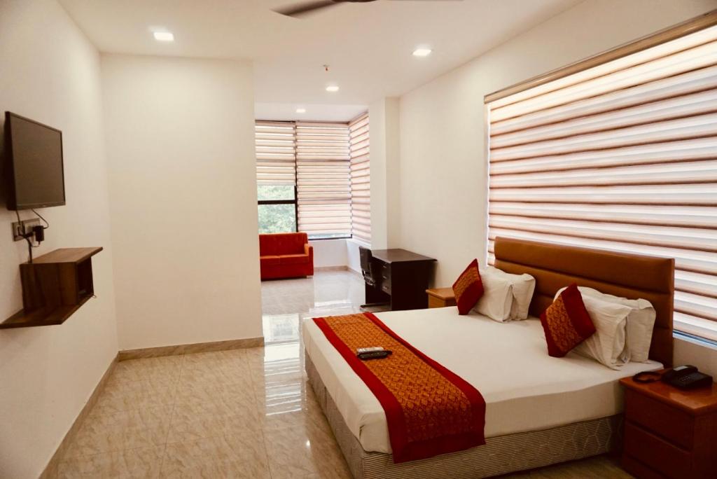 a bedroom with a bed with a large window at Amora Rooms Dwarka in New Delhi