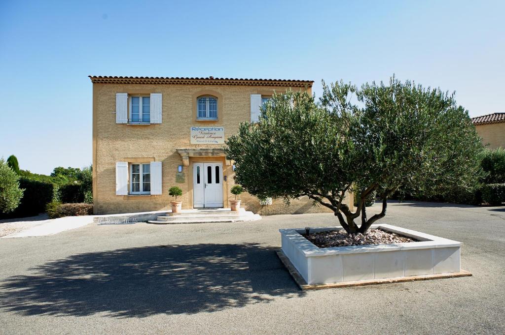 a large building with a tree in front of it at Residhotel Golf Grand Avignon in Vedène