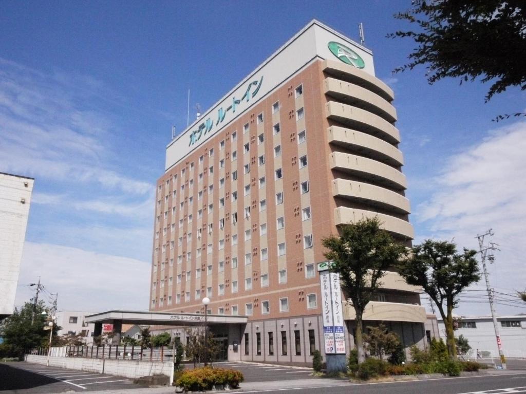 un gran edificio con un reloj encima en Hotel Route-Inn Suzuka en Suzuka