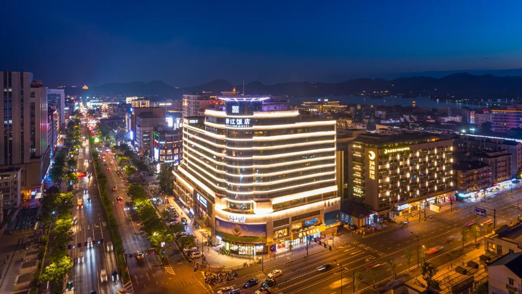 a city lit up at night with a large building at Zhejiang Hotel in Hangzhou
