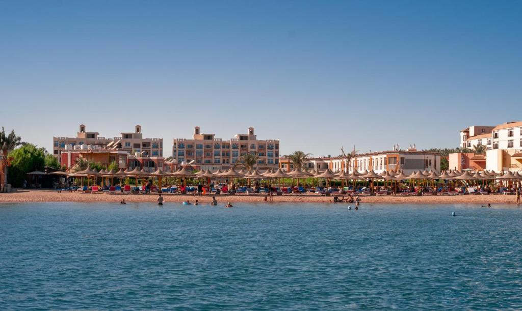 Andalusia Blue Beach Hurghada في الغردقة: شاطئ فيه مظلات وناس على الشاطئ