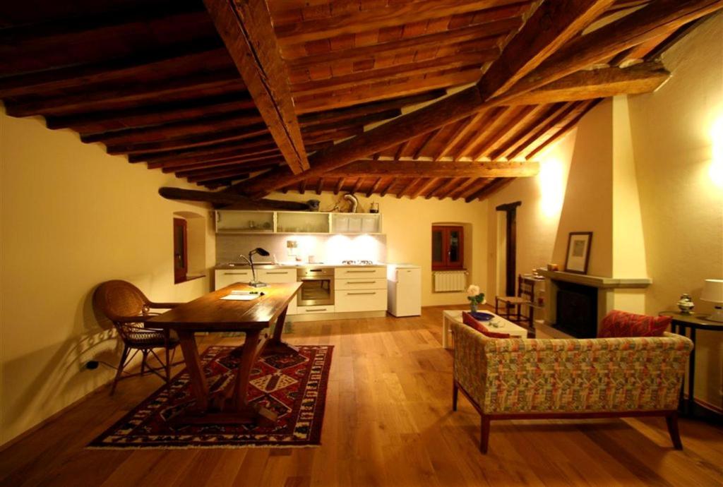 ein Wohnzimmer mit einem Tisch und einer Küche in der Unterkunft Orto di Cornelio in Cincelli