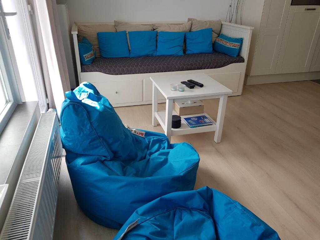a small living room with a couch and a table at Zeezucht in Koksijde
