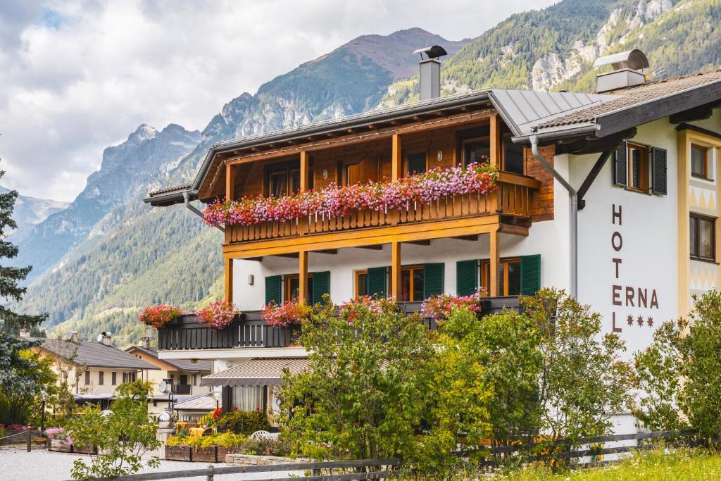 un edificio con un balcón con flores. en Hotel Erna en Colle Isarco