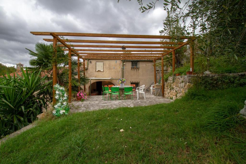 een patio met een tafel en stoelen in een tuin bij Casa dei Templari in Finale Ligure