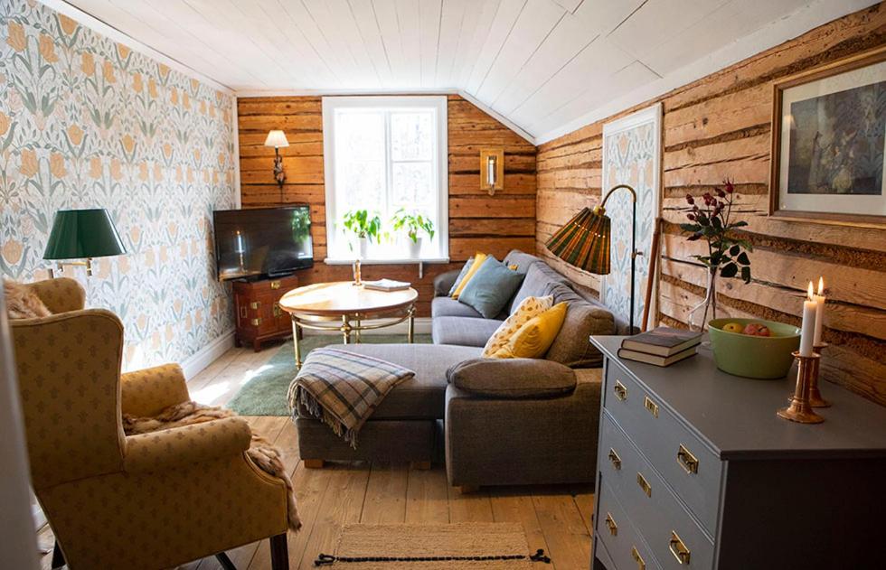 ein Wohnzimmer mit einem Sofa und einem Tisch in der Unterkunft HotelletDalkarlsberg in Gyttorp