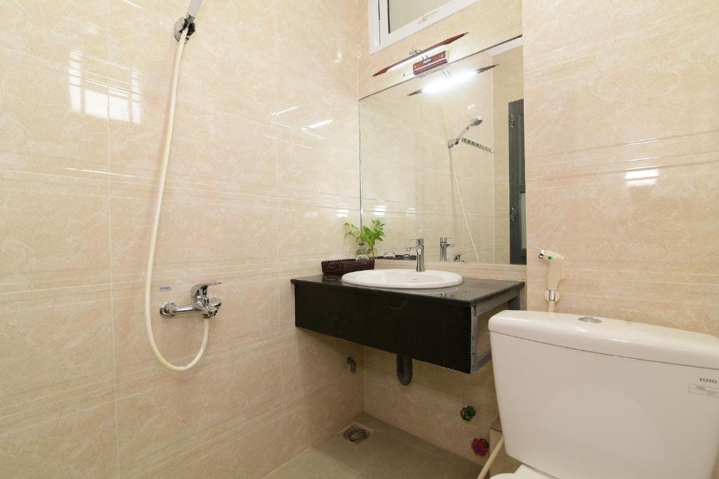 a bathroom with a sink and a shower and a toilet at Gấu's House in Vung Tau