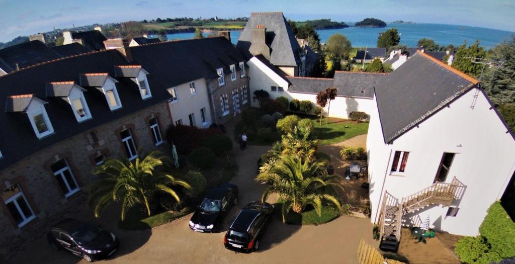 une vue aérienne sur une maison avec des voitures garées devant dans l'établissement Chambres d'hôtes "Le Clos de la Baie", à Paimpol