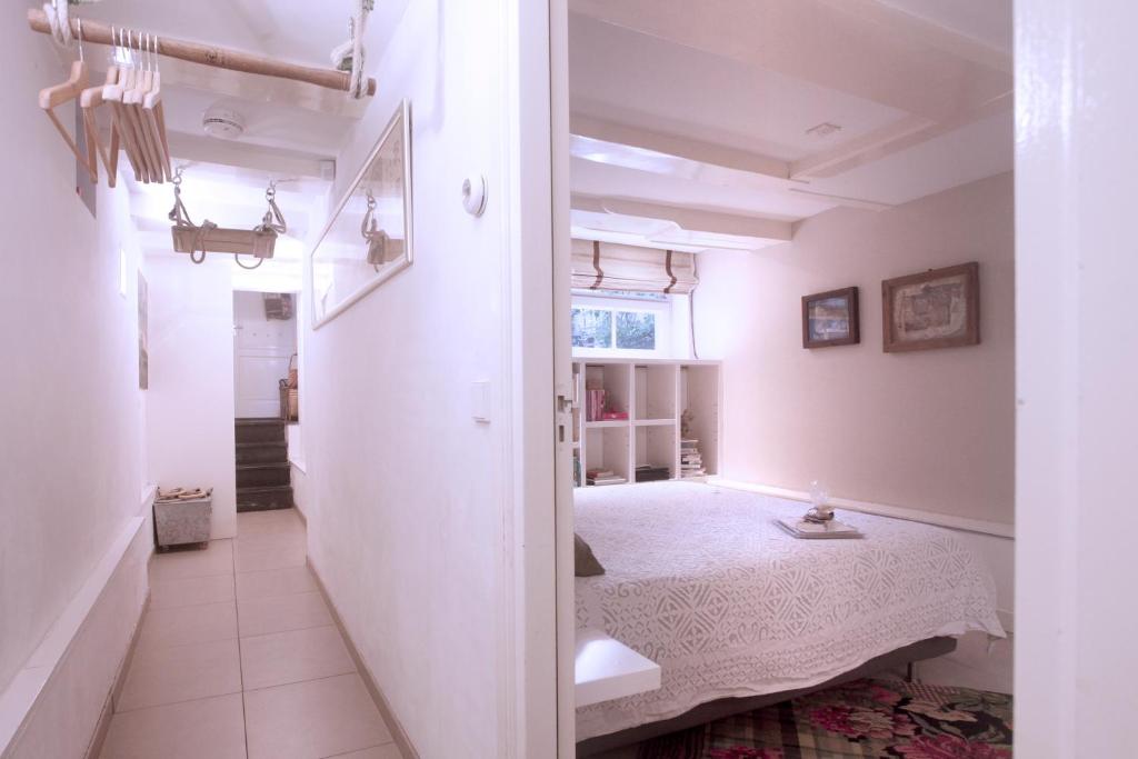 ein Schlafzimmer mit einem Bett in einem weißen Zimmer in der Unterkunft Cozy Canal Studio in Amsterdam