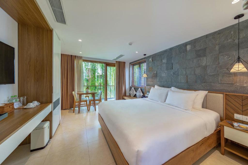 a bedroom with a large white bed and a table at Ponte Boutique Da Nang in Da Nang