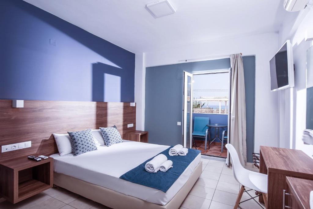 a bedroom with a bed and a table and a desk at Stalis Hotel in Stalís