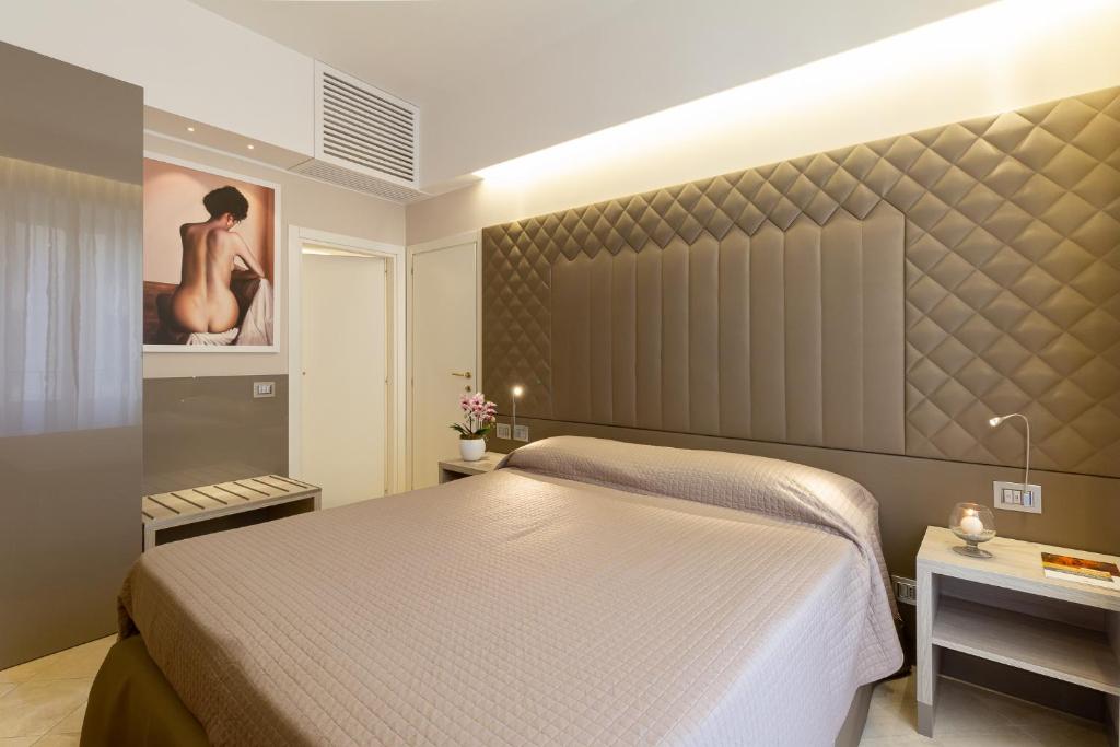 a bedroom with a bed and a painting on the wall at Harry's Bar Trevi Luxury Apartments - Spagna in Rome