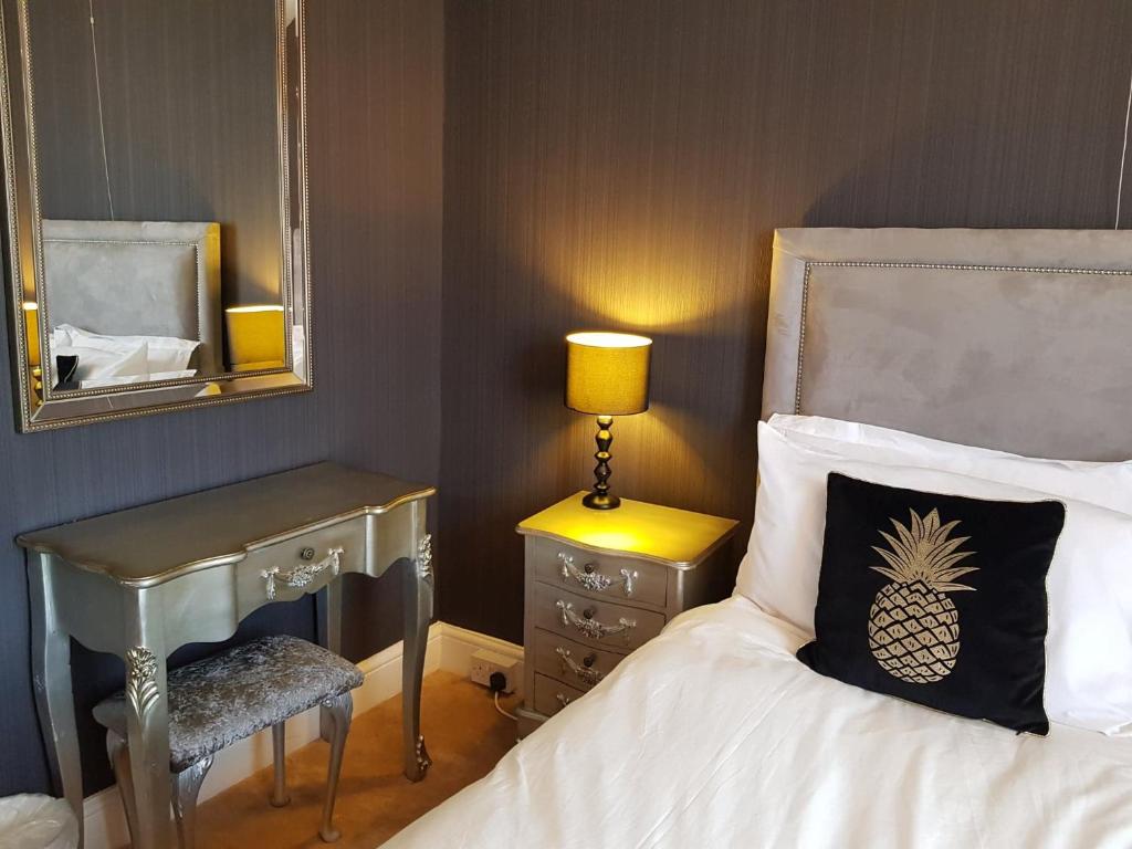 a bedroom with a bed and a desk with a pineapple pillow at The Skegness Hotel in Skegness