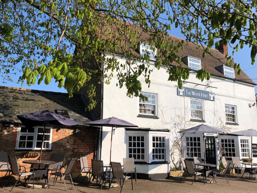 a white building with tables and chairs in front of it at The White Hart in Sherington