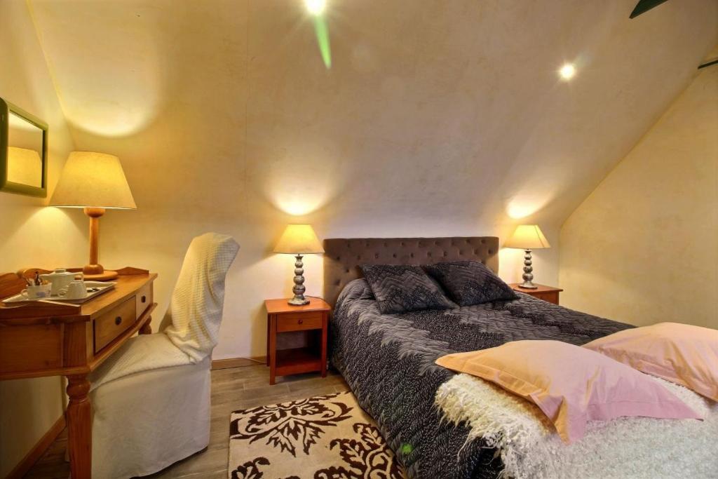 a bedroom with a bed and a desk and a chair at Chambres d&#39;hôtes Air Marin in Lannion