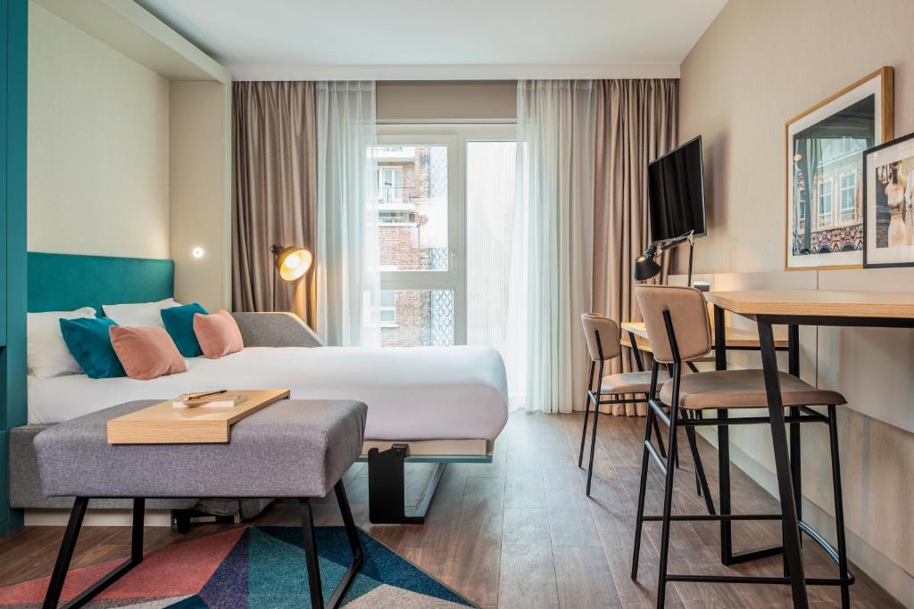 a hotel room with a bed and a desk at Aparthotel Adagio Lille Centre Grand Place in Lille