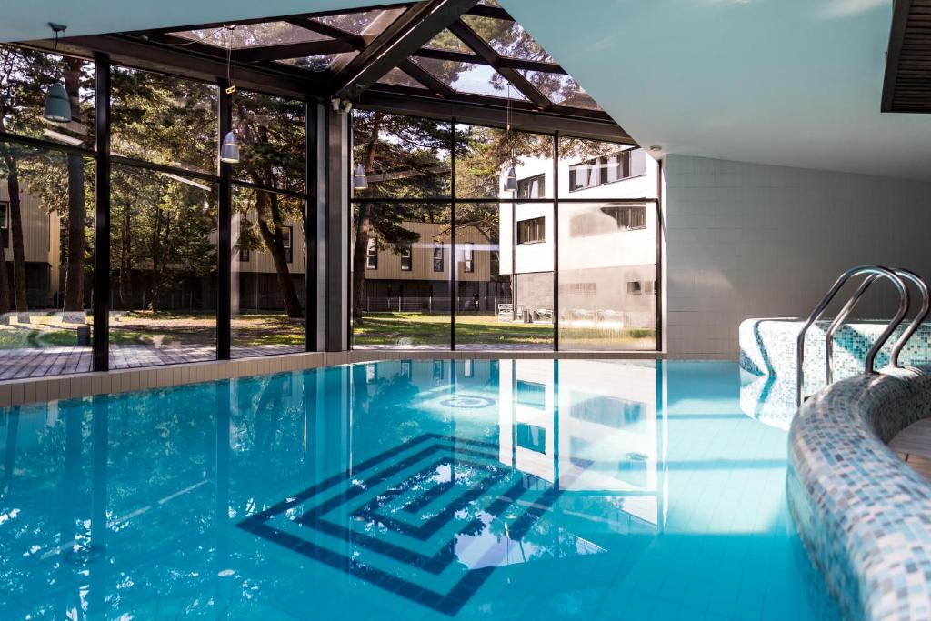 a swimming pool with a view of a building at Gabija Hotel SPA & Conferences in Palanga