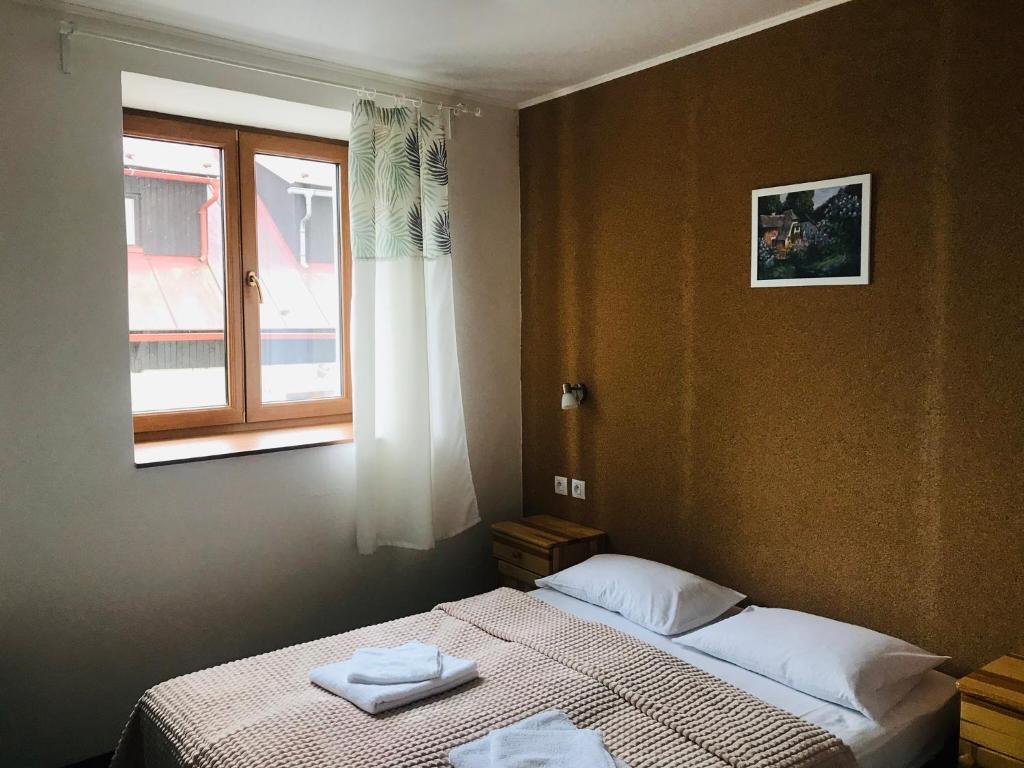 a bedroom with a bed with two towels on it at Mala Narnia in Frymburk