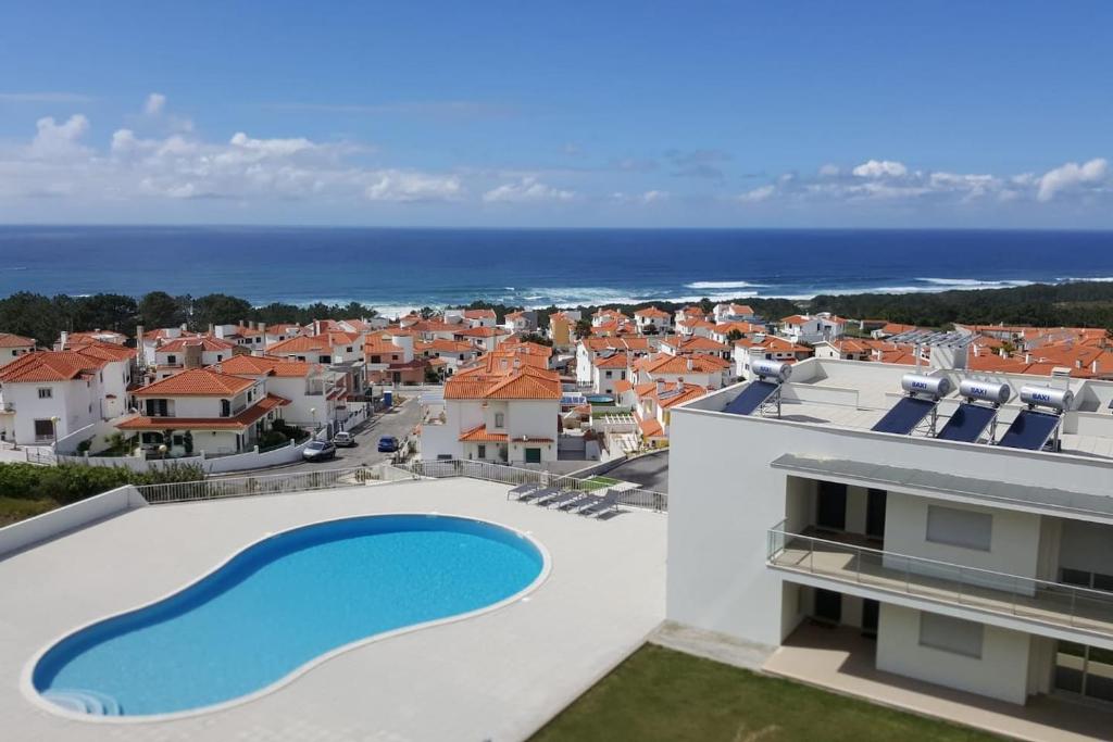 a villa with a swimming pool and a view of the ocean at Marco Polo Apartment in Nazaré