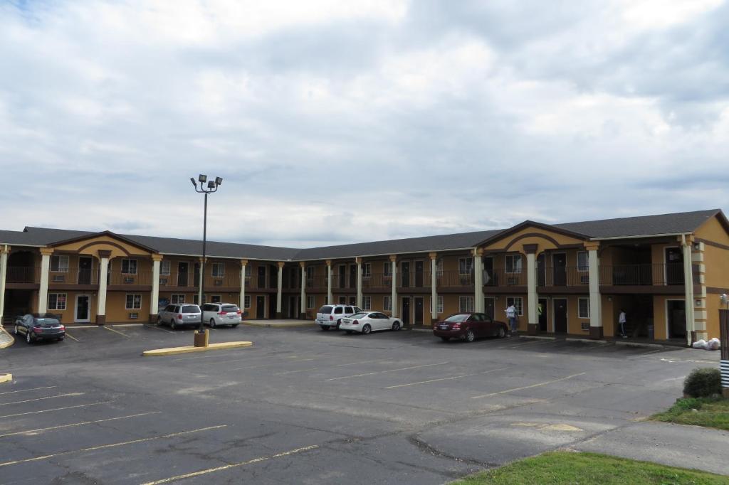 un grand bâtiment avec des voitures garées dans un parking dans l'établissement Economy Inn & Suites Joplin, à Joplin