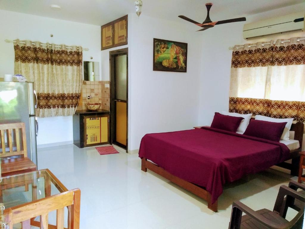 a bedroom with a purple bed in a room at DSK Studio Apartment, Siolim, Goa. in Siolim